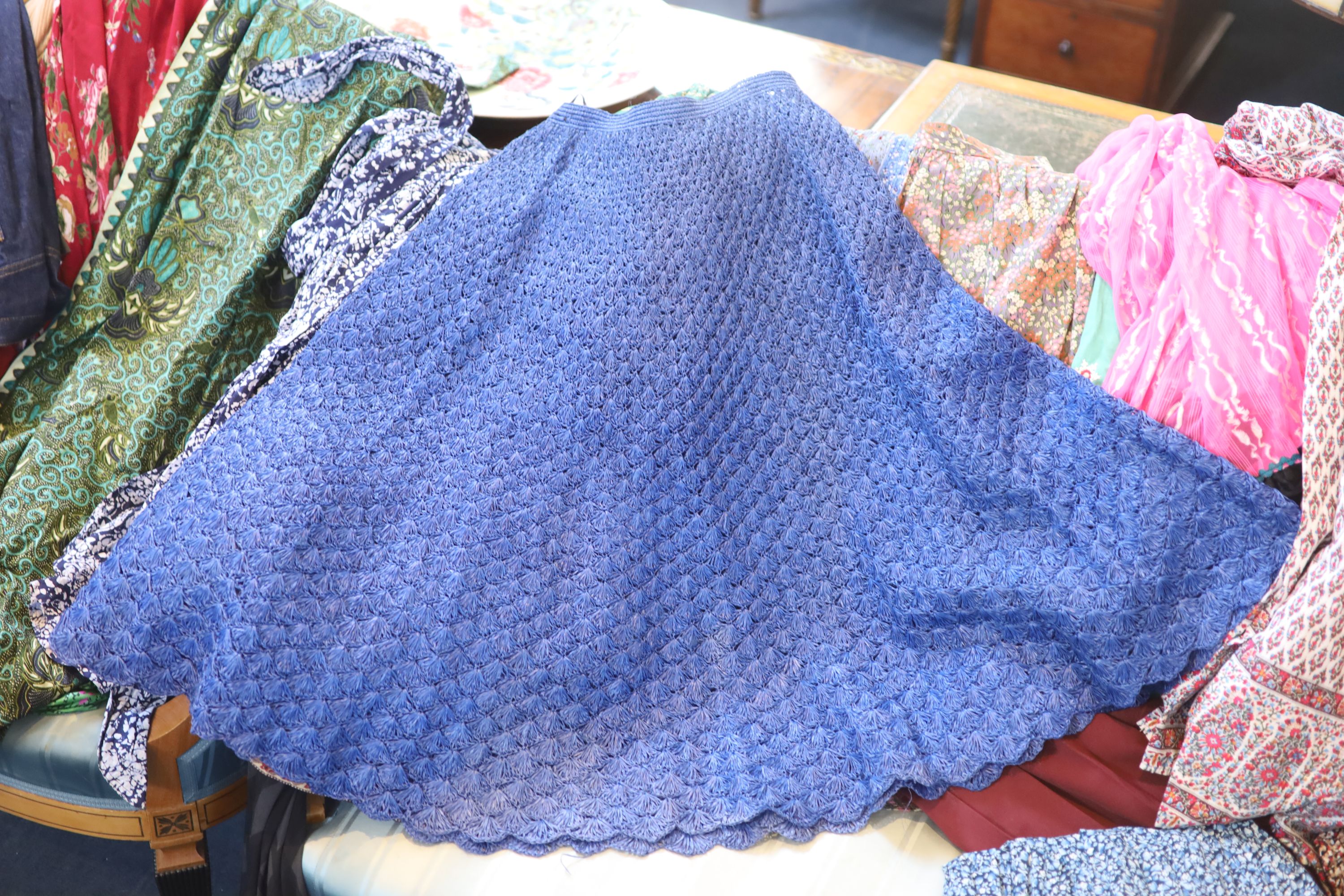 A large collection of fabric skirts including a raffier skirt in blue
